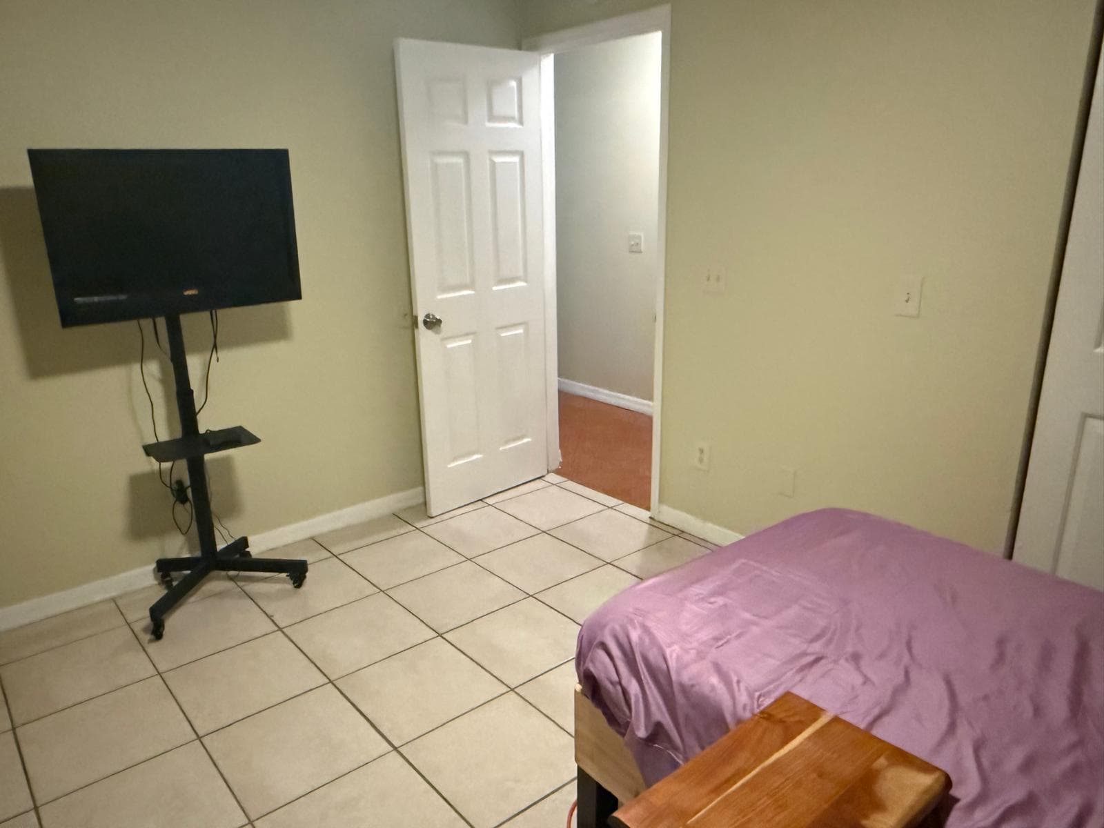Bedroom with a single bed, TV, and tile floor at ADOL FOSTER HOME in Tampa.